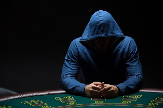 Portrait d'un joueur de poker professionnel assis à une table de poker