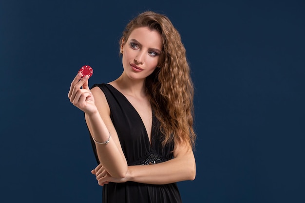 Portrait de la joueuse au casino gardant des jetons de poker dans la main