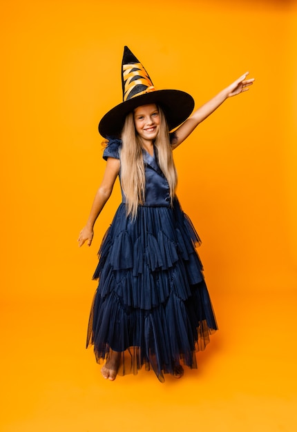 Portrait d'une joyeuse blonde en costume de sorcière posant pour la caméra. Halloween.