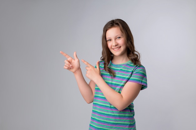 Portrait de joyeuse petite fille montrant les pouces vers le haut