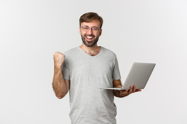 Portrait de joyeux beau mec à lunettes et t-shirt gris