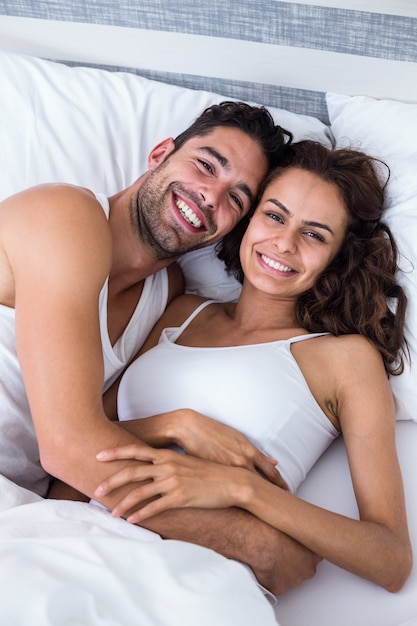 Portrait de joyeux couple de détente sur le lit