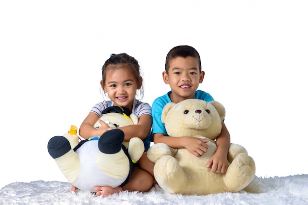 Portrait De Joyeux Petit Garçon Asiatique Et Fille Avec Deux Poupées Isolées Sur Fond Blanc