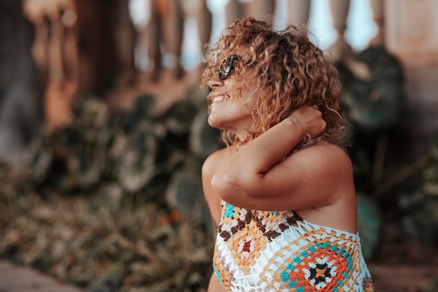 Portrait latéral d'une femme aux cheveux bouclés naturels en bonne santé souriant et s'amusant seule dans une activité de loisirs en plein air au parc pendant les vacances Voyage de vacances Liberté joie femmes mode de vie en plein air