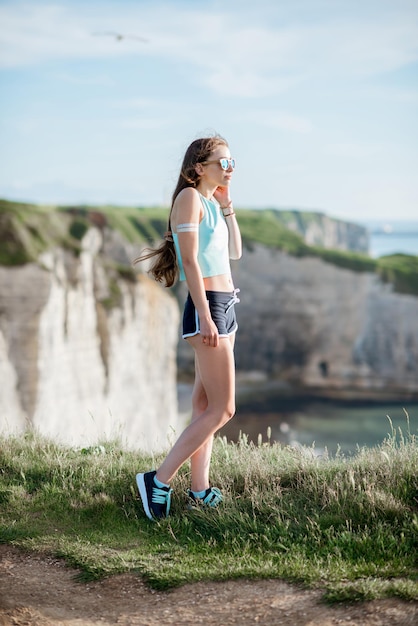 Portrait lifestyle d'une femme en tenue de sport après l'entraînement sur la magnifique côte rocheuse en France