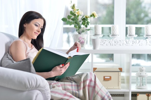 Portrait d'un livre de lecture de jeune femme brune