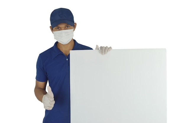 Portrait d'un livreur portant un masque médical et des gants médicaux tenant un panneau d'affichage vierge sur blanc