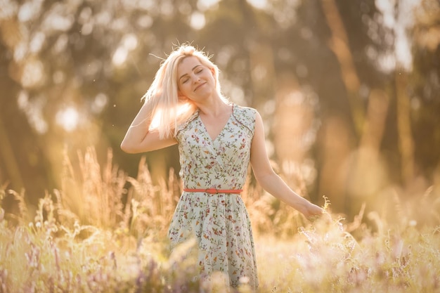 Portrait lumineux de femme heureuse au champ d'été