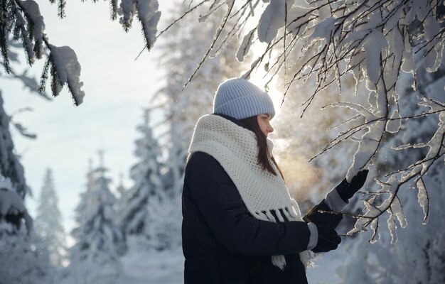 Portrait magique d'une femme touchant la neige sur les arbres avec espace de copie