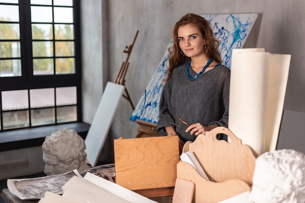 Photo portrait d'une magnifique artiste féminine travaillant sur un projet d'art dans son atelier