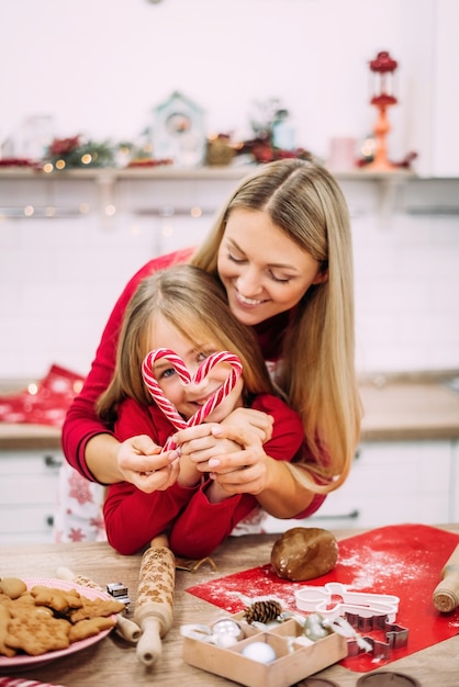 Portrait de maman heureuse et fille debout dans la cuisine et préparer des biscuits en pain d'épice