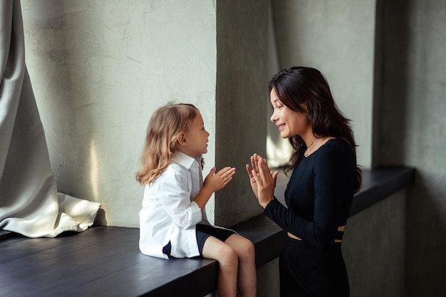 Portrait d'une maman heureuse avec sa fille de 3 ans qui s'amuse à l'intérieur du loft