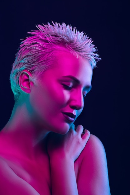 Portrait de mannequin femme en néon sur l'obscurité.