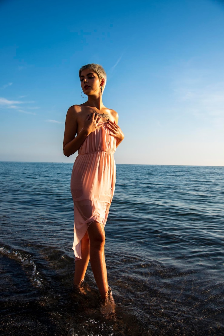 Photo portrait d'un mannequin à la mode de plage au coucher du soleil