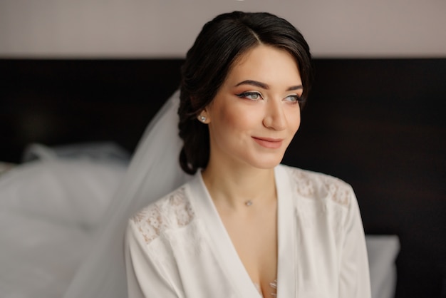 Portrait de mariée au matin du mariage. Belle mariée avec maquillage et coiffure style souriant.