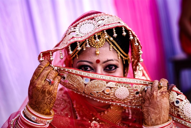 Portrait de la mariée cachant le visage avec un foulard lors de la cérémonie de mariage