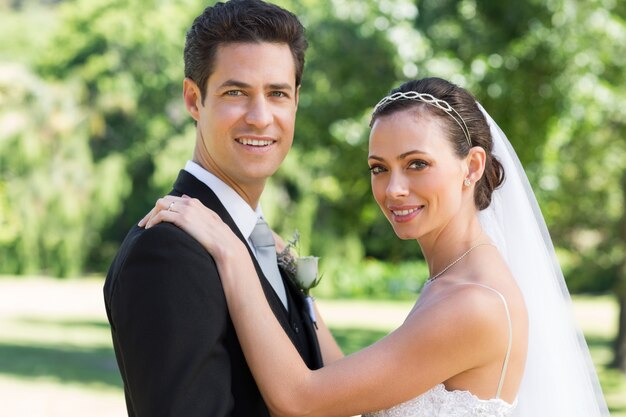 Portrait de la mariée et le marié souriant ensemble dans le jardin