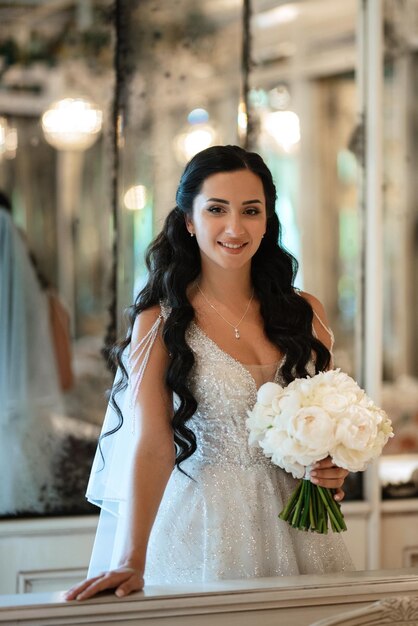 Portrait d'une mariée en robe blanche dans un café lumineux