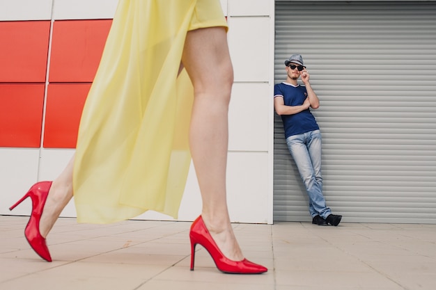 Portrait d'un mec devant une fille en chaussures rouges