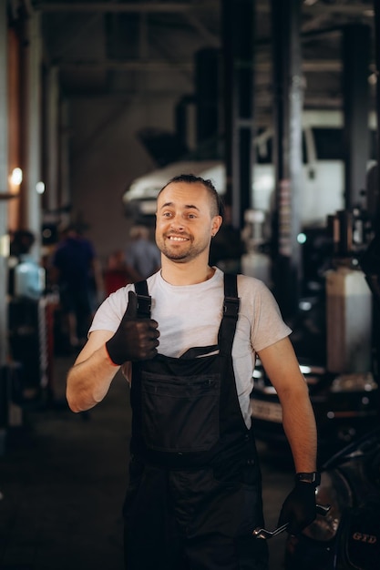 Portrait d'un mécanicien automobile heureux qui nettoie ses mains avec un chiffon