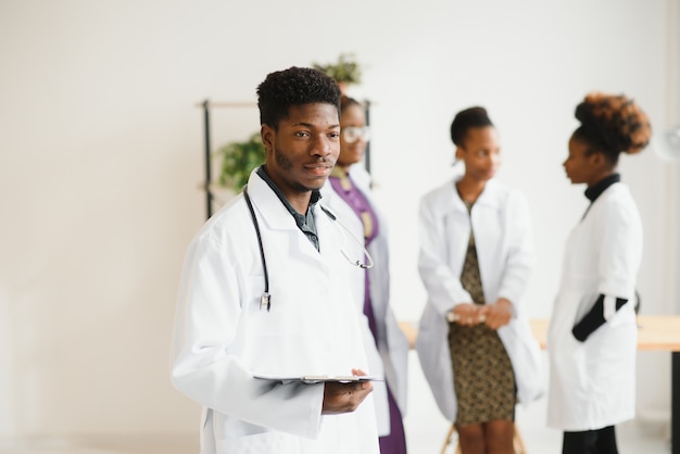 Portrait d'un médecin africain devant son équipe médicale