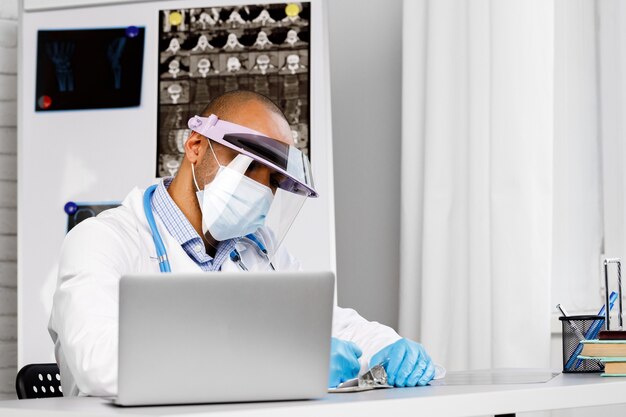 Photo portrait de médecin afro-américain en masque médical avec stéthoscope