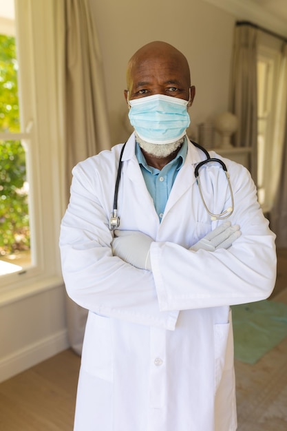 Photo portrait d'un médecin afro-américain senior portant un masque facial et une blouse de laboratoire. retraite et mode de vie des personnes âgées pendant le concept de pandémie covid 19.