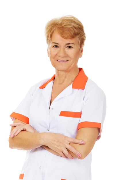 Photo portrait d'un médecin âgé souriant avec les bras croisés debout sur un fond blanc