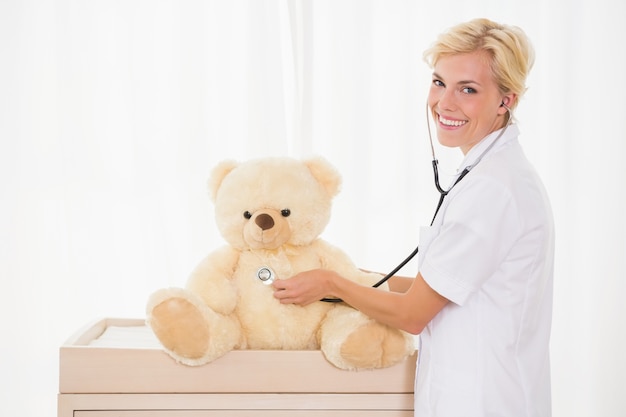 Portrait d&#39;un médecin blond avec stéthoscope et ours en peluche