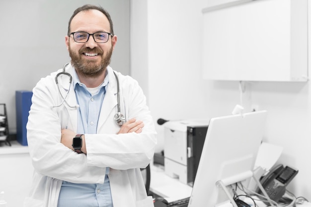 Portrait d'un médecin confiant croisant les mains et souriant à la caméra