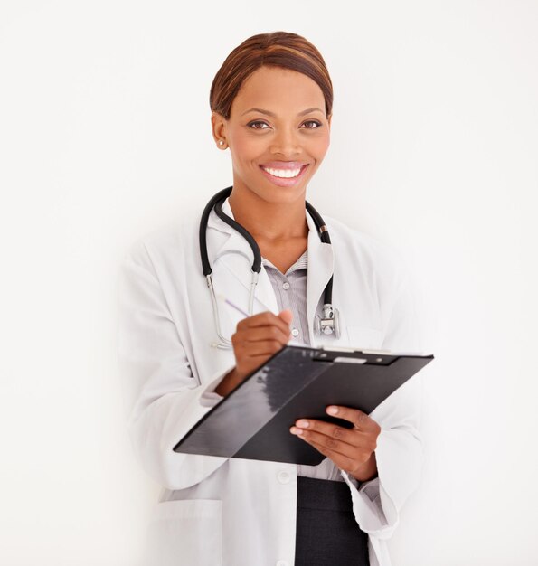 Photo portrait de médecin femme et dossier ou documents pour l'information médicale résultats de tests ou évaluation en studio visage d'un professionnel de la santé écrivant dans des graphiques ou une liste de contrôle sur un mur ou un fond blanc