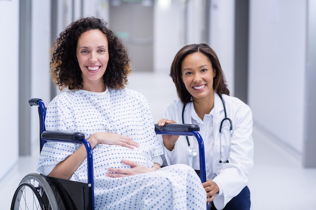 Portrait de médecin et femme enceinte dans le couloir