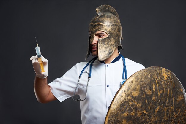 Portrait d'un médecin guerrier médiéval dans un casque tenant une seringue