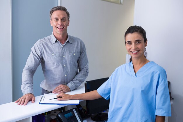 Portrait de médecin joyeux et homme debout au bureau