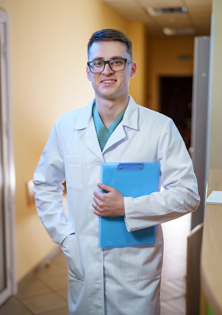 Portrait d'un médecin ou d'un médecin spécialiste. Portrait vertical. Homme en gommage. Papiers en mains.