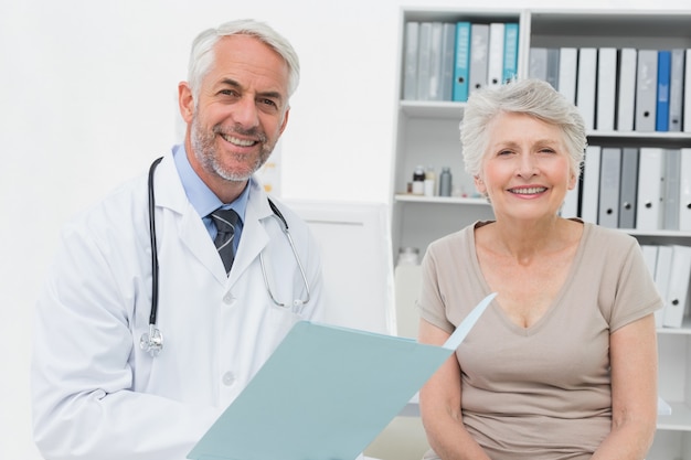 Portrait d'un médecin et patient senior avec des rapports