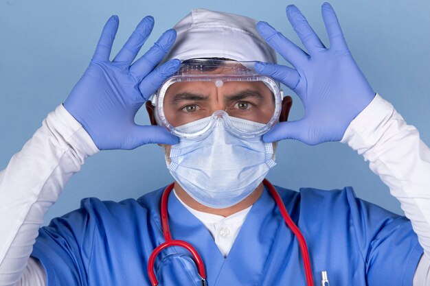 Portrait de médecin portant un masque de protection, des lunettes médicales et un stéthoscope