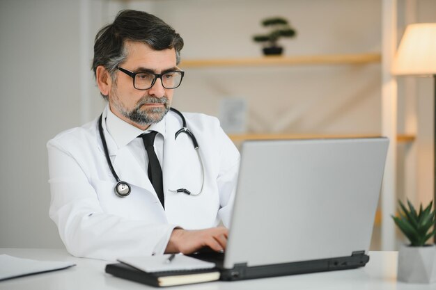 Portrait d'un médecin senior en blouse blanche sur le lieu de travail