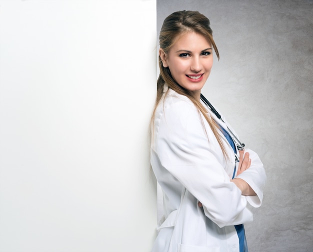 Portrait d&#39;un médecin souriant appuyé contre un tableau blanc