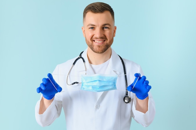 Portrait d'un médecin souriant sur fond bleu concept de soins de santé