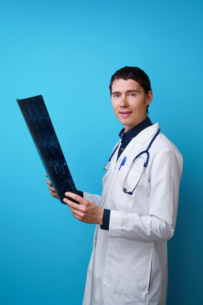 Portrait d'un médecin avec un stéthoscope sur le cou et une radiographie à la main