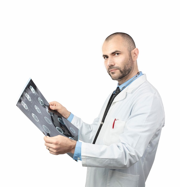 Portrait d'un médecin tenant une radiographie alors qu'il se tient sur un fond blanc