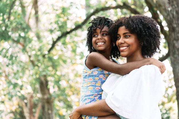 Portrait d'une mère afro-américaine tenant une petite fille souriante et heureuse