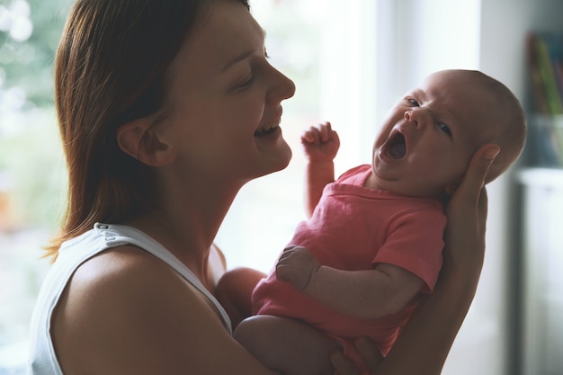 Portrait de mère et bébé belle femme tenant un bébé enfant dans ses bras