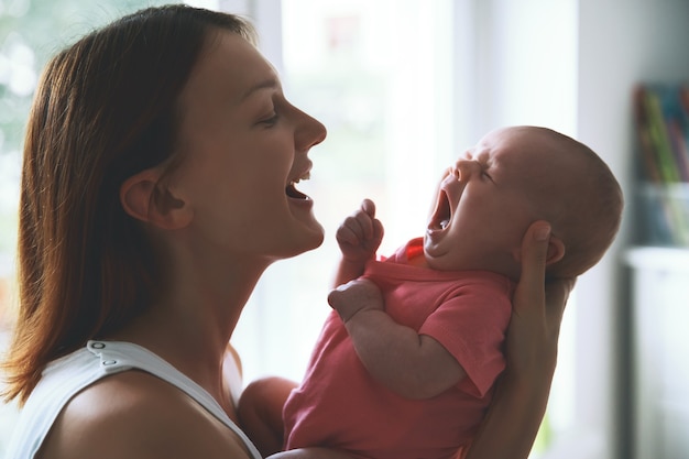 Portrait de mère et bébé belle femme tenant un bébé enfant dans ses bras