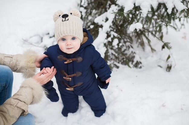 Portrait d'une mère et d'un bébé heureux dans le parc d'hiver