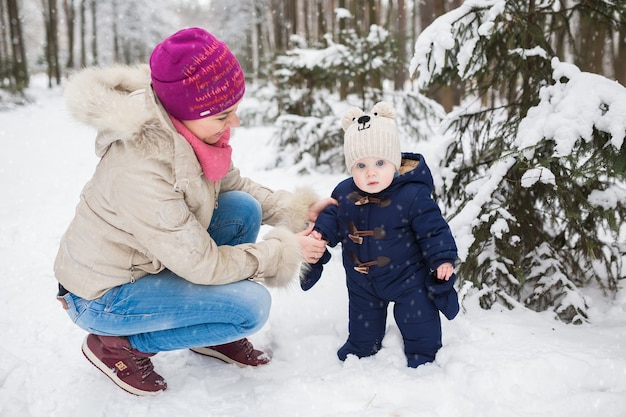 Portrait d'une mère et d'un bébé heureux dans le parc d'hiver