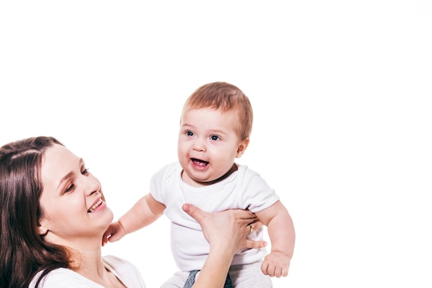 Portrait d'une mère et d'un enfant heureux embrassant joue contre joue sur fond blanc. Mère aux yeux fermés tenant la main de bébé