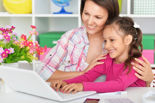 Portrait de mère et fille à l'aide d'un ordinateur portable