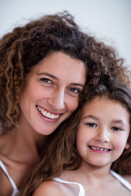 Portrait de mère et fille embrassant sur le lit